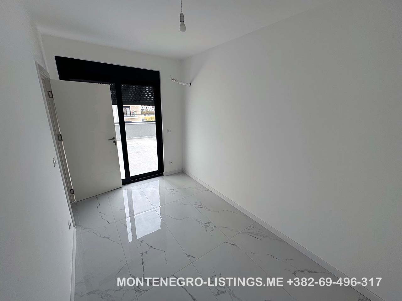 Bright, modern room in Ulcinj featuring white walls, marble tile, large window. Listed on montenegro-listings.me by ekosphere doo.