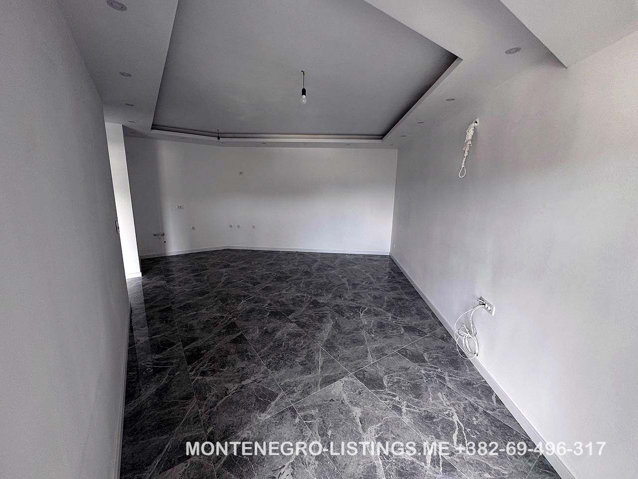 Spacious, modern room in Ulcinj with white walls, marble floors, and recessed lights&mdash;exclusive property at montenegro-listings.me.