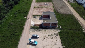 Prime aerial view of an unfinished brick property on spacious land in Ulcinj, Montenegro—ideal for investors via montenegro-listings.me.