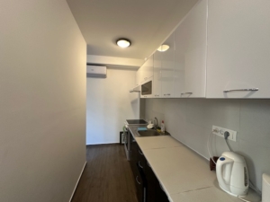 Modern kitchen in Ulcinj property: sleek white and dark cabinets, full appliances, air conditioning. Invest via montenegro-listings.me by ekosphere doo.