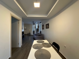 Modern dining area with white table, elegant living room, and premium finishes—exclusive Ulcinj property at montenegro-listings.me by Ekosphere Doo.