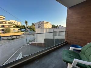 Modern balcony with glass railing, stylish seating and table, overlooking prime Ulcinj real estate—Exclusive at montenegro-listings.me by Ekosphere DOO.