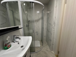 Luxurious Ulcinj bathroom with elegant marble walls, premium fixtures, and stylish shower—ideal Montenegro investment from ekosphere doo.