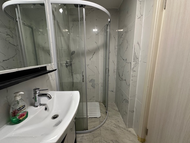 Luxurious Ulcinj bathroom with elegant marble walls, premium fixtures, and stylish shower&mdash;ideal Montenegro investment from ekosphere doo.