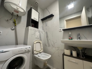 Modern Ulcinj bathroom with washer, heater, marble tiles—smart real estate investment by Ekosphere on montenegro-listings.me.