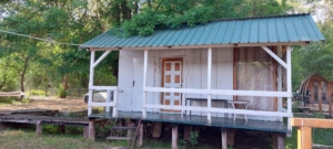 Eco-friendly wooden cabin with green roof and white features on raised deck; prime Ulcinj real estate by montenegro-listings.me/Ekosphere.