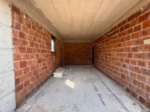 Spacious unfinished brick room with concrete floor, window, prime Ulcinj real estate—investment via montenegro-listings.me by ekosphere doo.