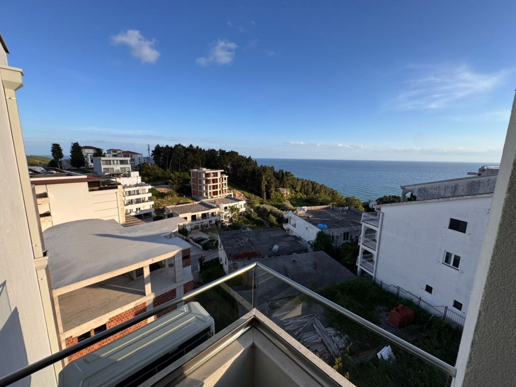 Premium balcony views of Ulcinj real estate—white homes, lush hills, distant blue sea. Invest with montenegro-listings.me by ekosphere doo.