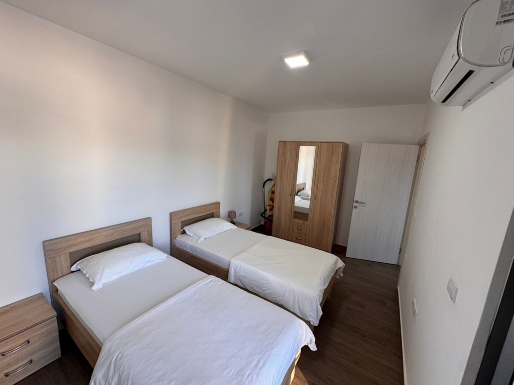 Invest in Ulcinj, Montenegro: stylish bedroom with twin beds, wood floors, AC. Listed by montenegro-listings.me—ekosphere doo project.