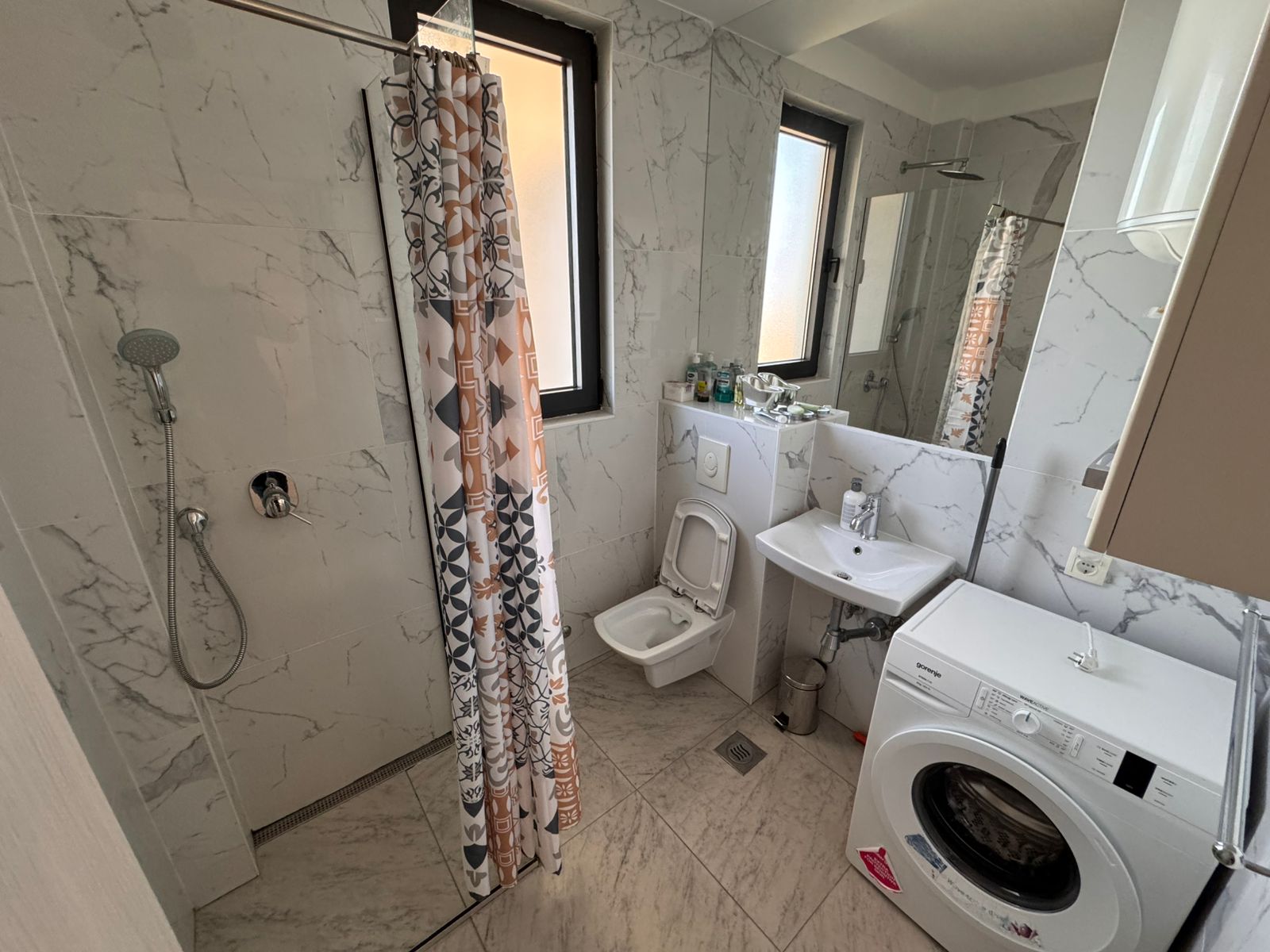 Modern Ulcinj Montenegro bathroom with marble tiles, bright windows, washer; ideal property investment. montenegro-listings.me by ekosphere doo.
