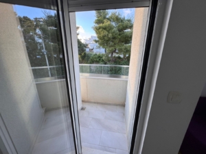 Bright balcony with beige tiles and glass railing in Ulcinj—ideal property investment. View at montenegro-listings.me by ekosphere doo.