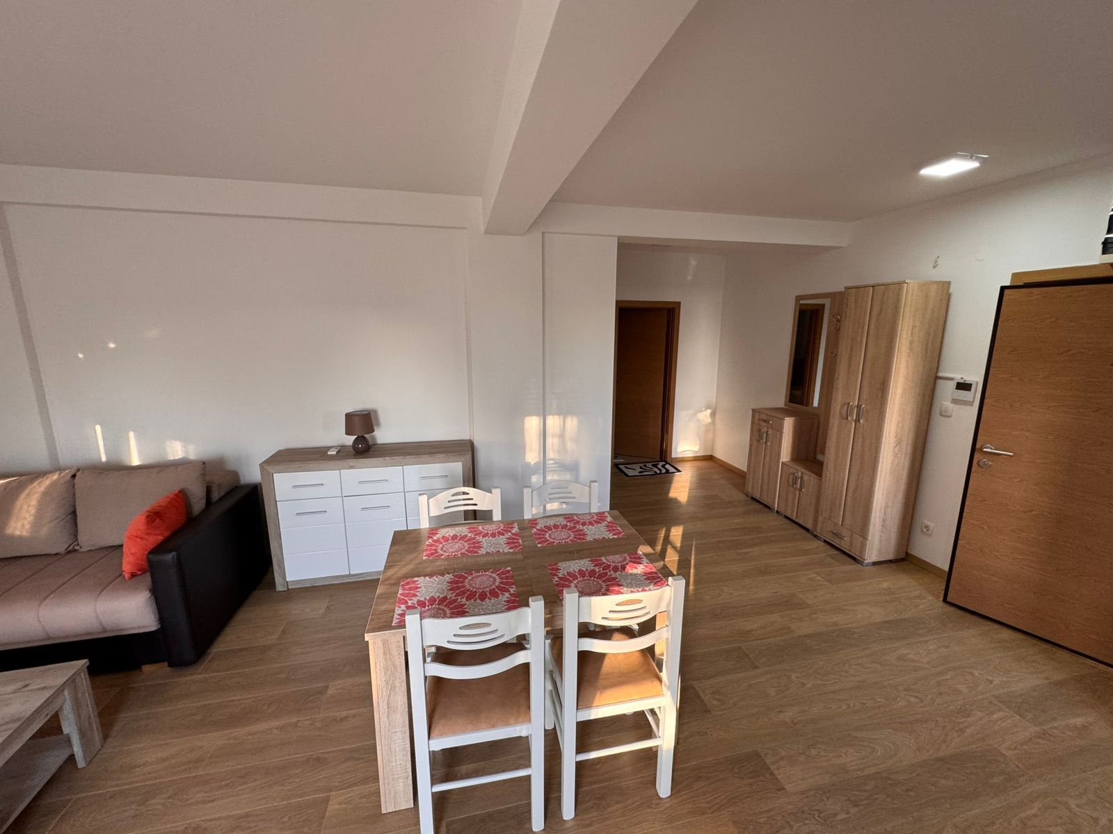 Elegant dining area with wooden table, sideboard, and sofa, ideal Ulcinj investment. Montenegro-listings.me by ekosphere doo.