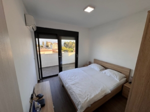 Luxurious Ulcinj Montenegro bedroom with double bed, AC, elegant wood décor & balcony views—exclusive on montenegro-listings.me by ekosphere doo.