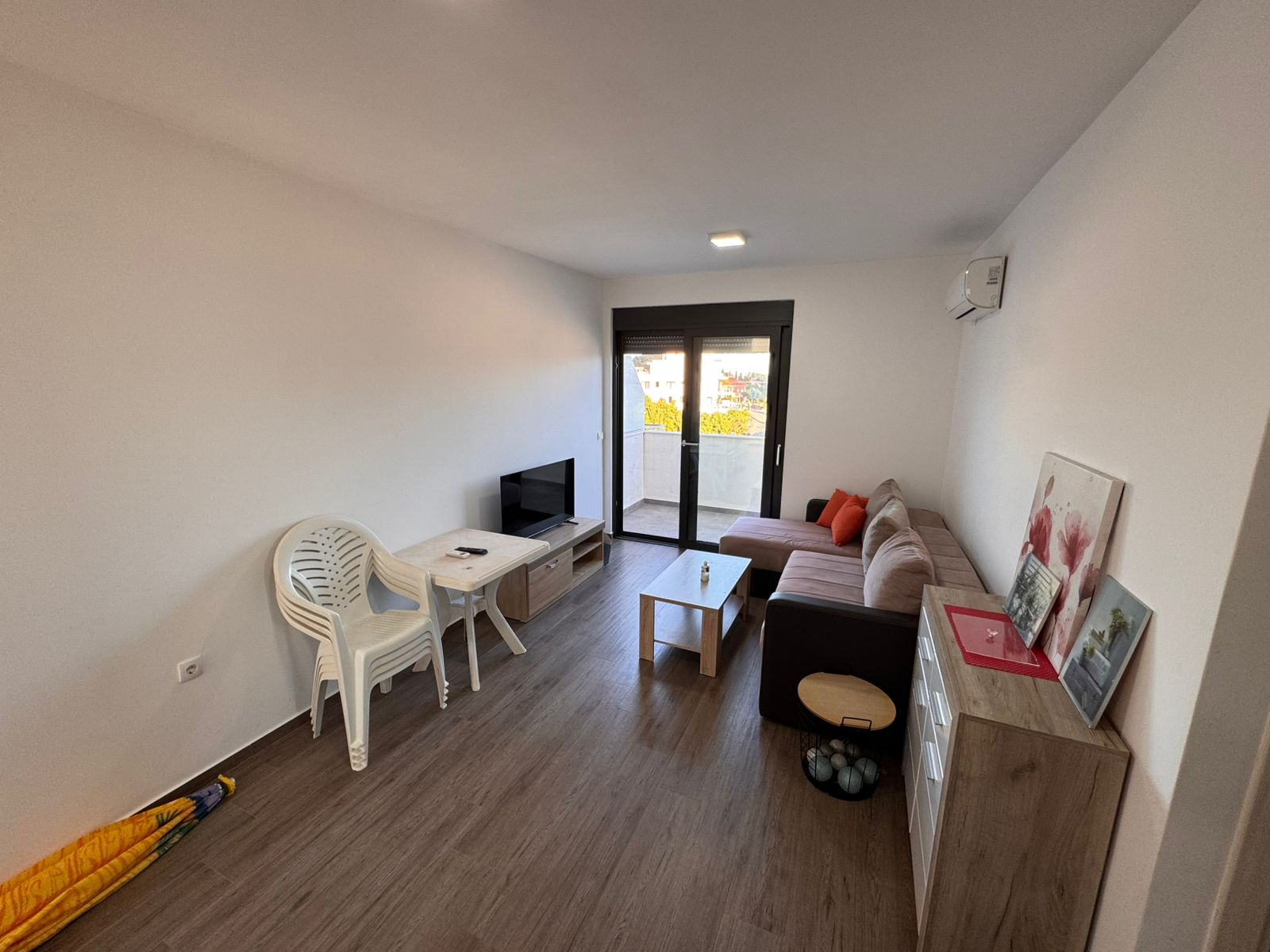 Modern Ulcinj, Montenegro living room with brown sofa, wooden coffee table, balcony views. Invest via montenegro-listings.me by ekosphere doo.