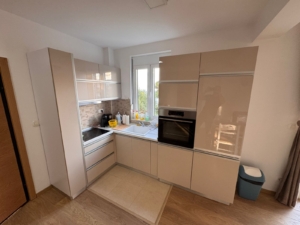 Stylish modern kitchen in Ulcinj with beige cabinets, built-in oven, and wooden flooring—exclusive on montenegro-listings.me by ekosphere doo.