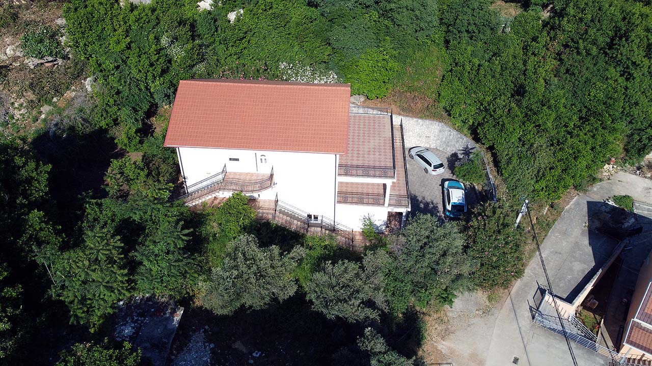 Aerial view of a modern white house with red roof in lush Ulcinj, perfect real estate investment by ekosphere doo, montenegro-listings.me.