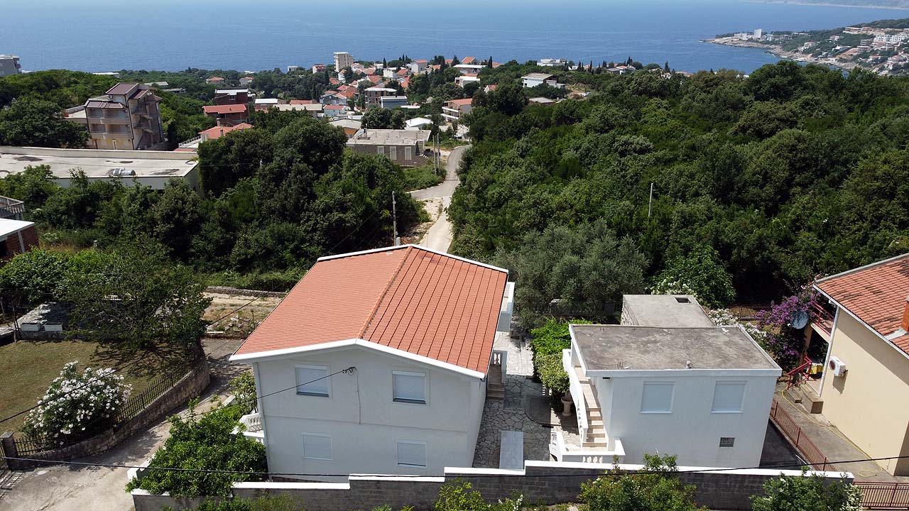 Stunning aerial of white villas with red roofs amid greenery in Ulcinj, Montenegro—prime investment via montenegro-listings.me by ekosphere doo.