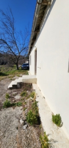 Modern beige building with concrete steps, set amid open greenery under Ulcinj’s blue sky—exclusive on montenegro-listings.me by ekosphere doo.