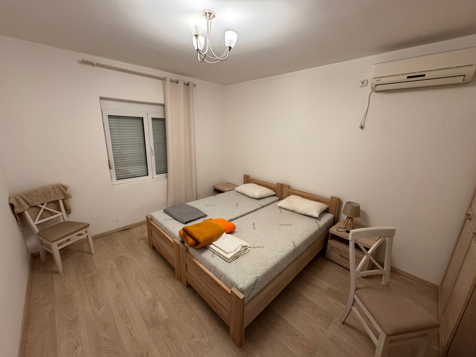 Bright Ulcinj bedroom with twin beds, A/C, window, modern lighting—ideal Montenegro investment via montenegro-listings.me by Ekosphere doo.