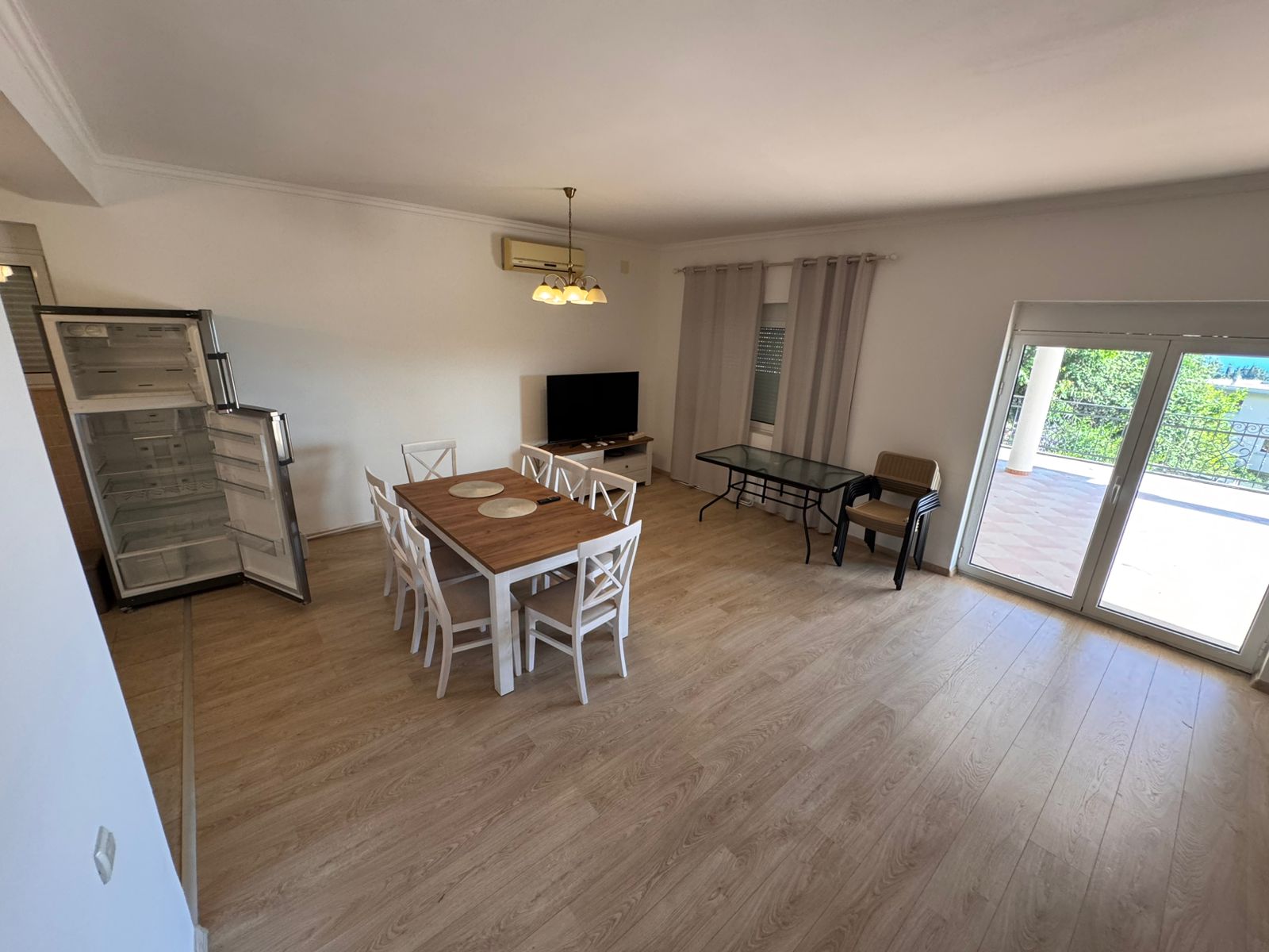 Modern, spacious Ulcinj apartment with light wood floors, dining area, open kitchen, and large windows—exclusive at montenegro-listings.me by ekosphere doo.
