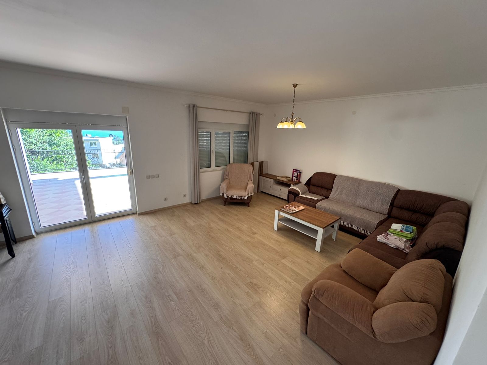 Elegant Ulcinj apartment: light wood floors, brown sectional, balcony access. Invest via montenegro-listings.me by ekosphere doo.