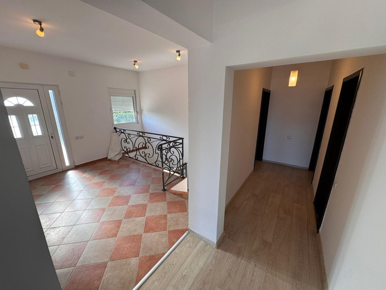 Sunlit entryway with tiled floor, elegant railings, and wood-floored hallway&mdash;prime Ulcinj real estate by montenegro-listings.me/Ekosphere doo.