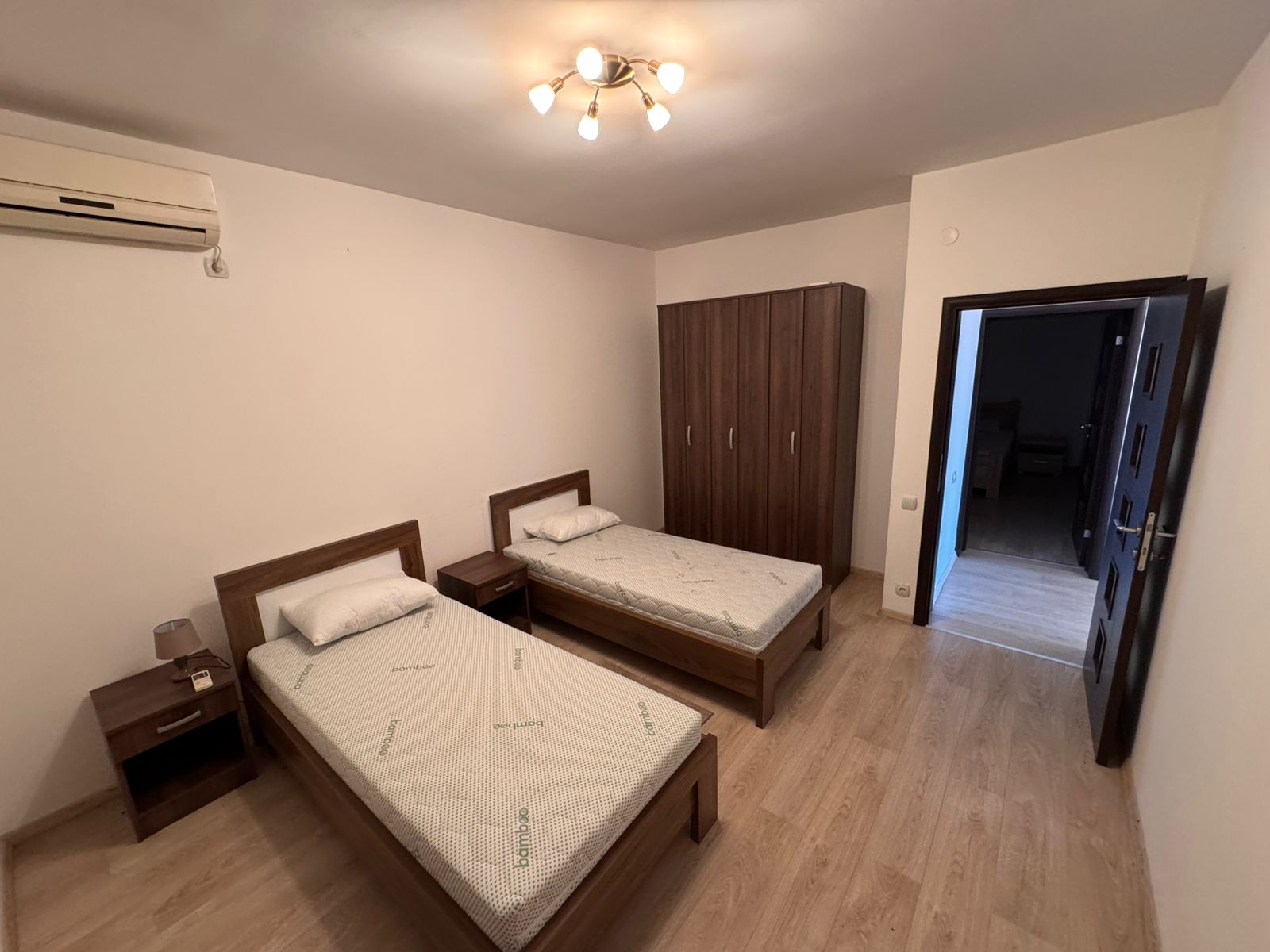 Modern Ulcinj bedroom with two single beds, wood flooring, AC, wardrobe&mdash;ideal Montenegro investment via montenegro-listings.me.