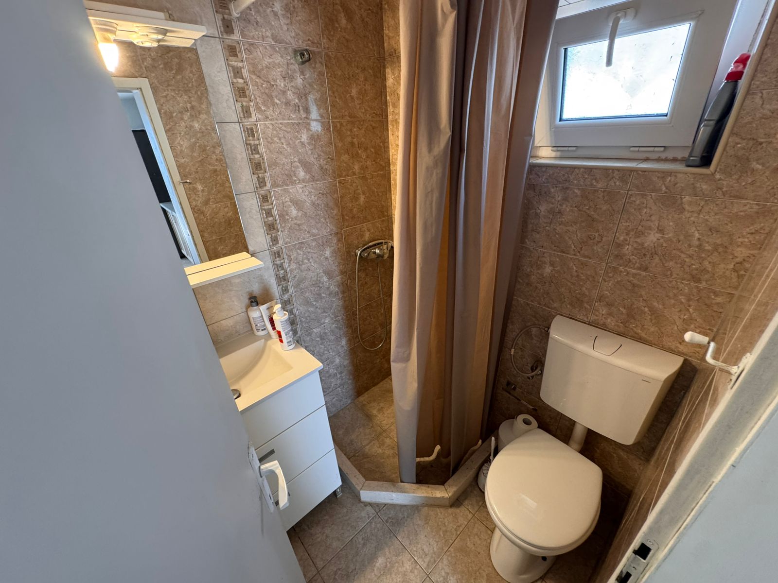 Modern bathroom in Ulcinj property: brown tiles, shower, sink, toilet. Great investment via montenegro-listings.me by ekosphere doo.
