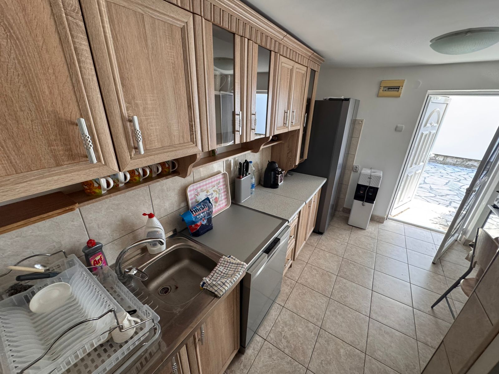 Sunlit kitchen with wooden cabinets, modern appliances, and patio access in Ulcinj—premium eco real estate by ekosphere at montenegro-listings.me.