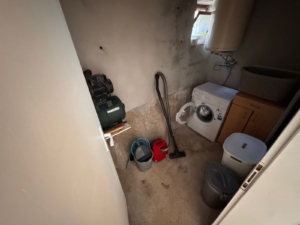 Modern utility room in Ulcinj property—washer, water heater, storage essentials. Ideal real estate investment via montenegro-listings.me.