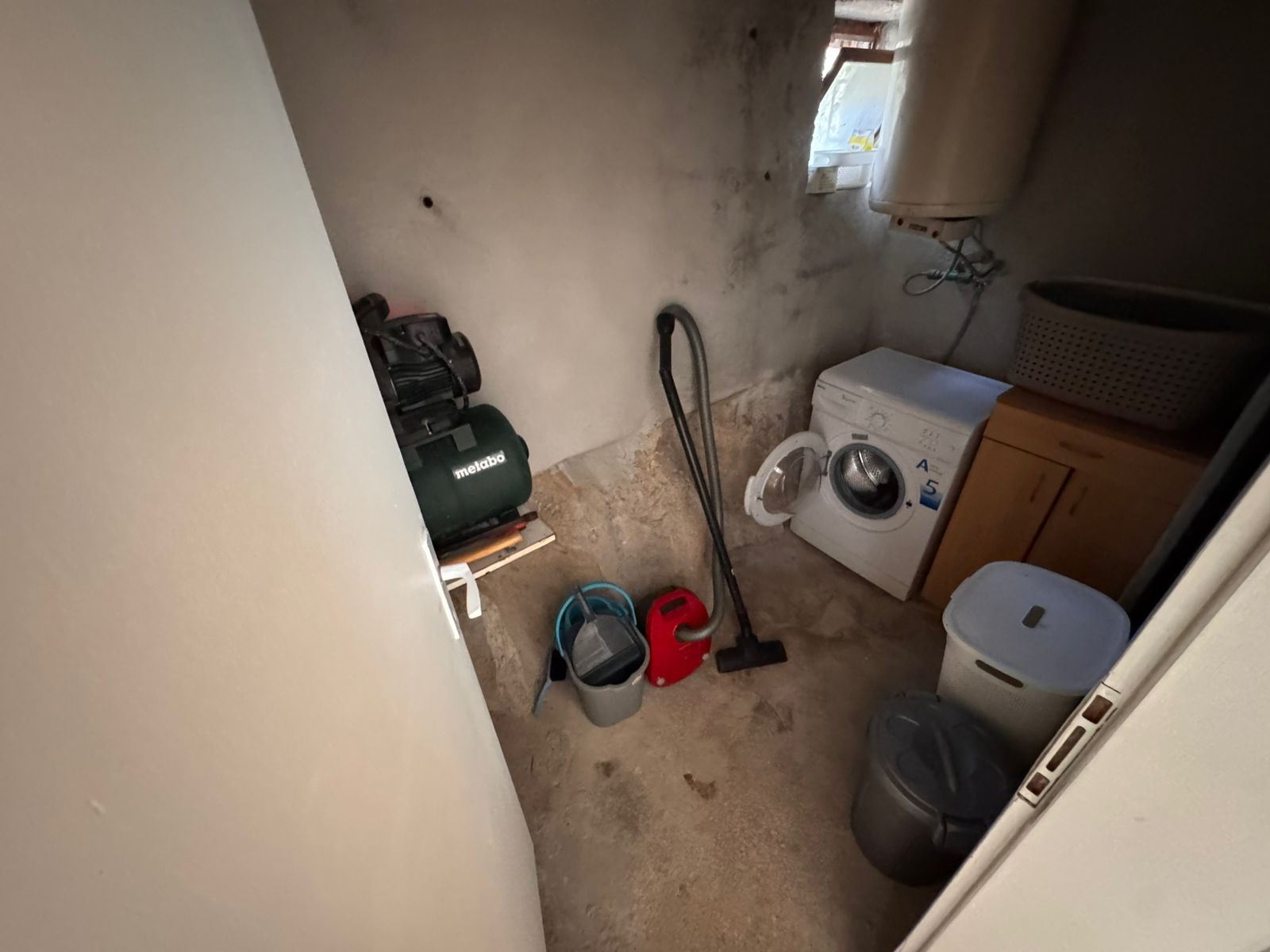 Modern utility room in Ulcinj property—washer, water heater, storage essentials. Ideal real estate investment via montenegro-listings.me.