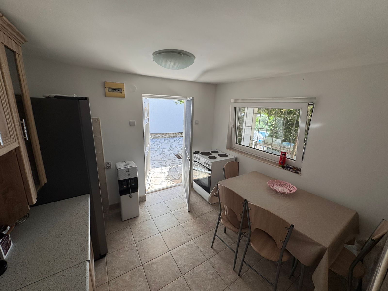 Charming Ulcinj kitchen with dining area, appliances & stone patio access. Ideal Montenegro property by Ekosphere doo via montenegro-listings.me.