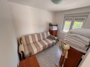Discover a cozy, meticulously maintained Ulcinj property featuring a stylish striped sofa, desk, and storage; invest with montenegro-listings.me by ekosphere doo.
