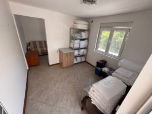 Modern tiled utility room in Ulcinj, Montenegro with organized storage, natural light, and adjoining lounge—exclusive at montenegro-listings.me by ekosphere doo.