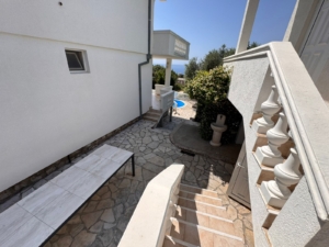 Elegant stone steps and walkway lead to a sunny tiled patio and pool—prime Ulcinj real estate with montenegro-listings.me by Ekosphere.
