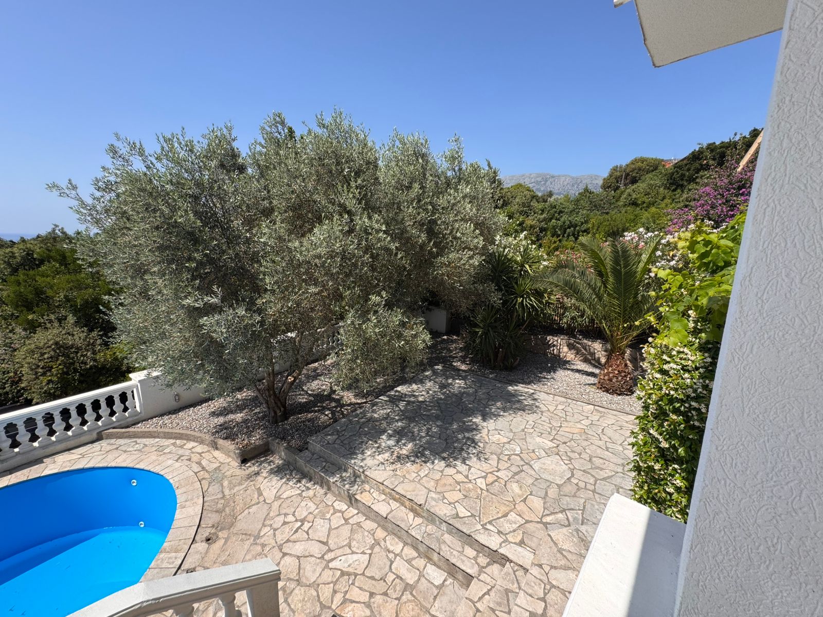 Premium Ulcinj property: stone patio, lush garden, pool & blue skies. Invest in Montenegro real estate with montenegro-listings.me by ekosphere doo.