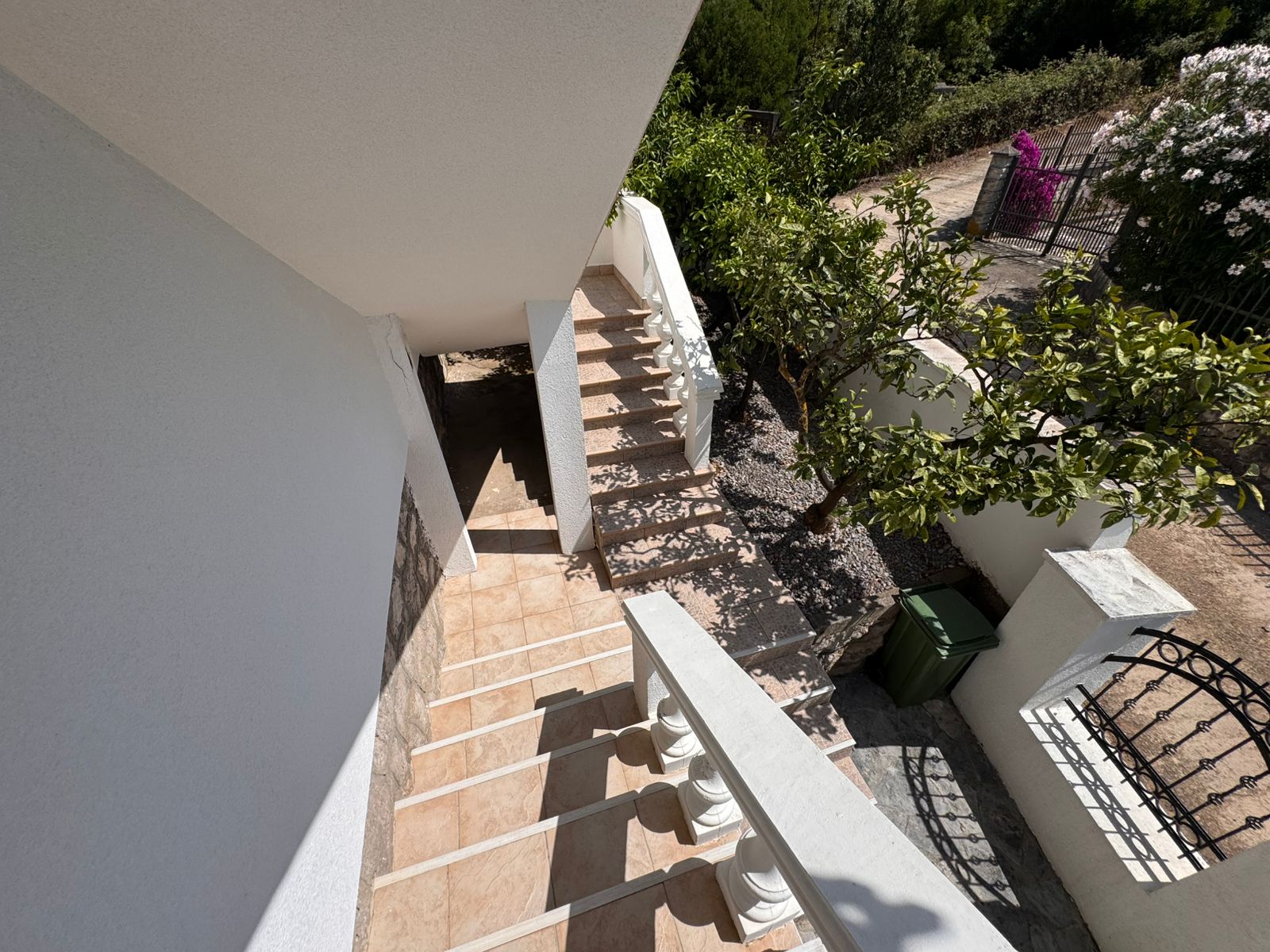 Inviting tiled staircase with white railings leads to lush garden&mdash;prime investment in Ulcinj. Listed by ekosphere doo at montenegro-listings.me.