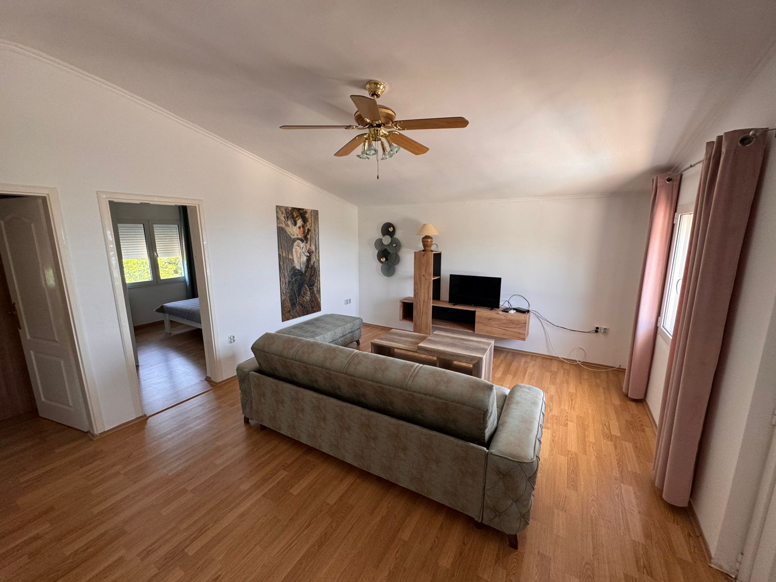 Modern Ulcinj Montenegro property: bright living room, green sofa, wood floors, stylish d&eacute;cor&mdash;exclusive at montenegro-listings.me by ekosphere doo.