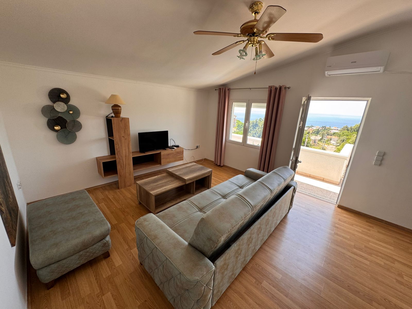 Modern Ulcinj apartment: wood floors, cozy sofa, balcony with sea & green views. Prime investment via montenegro-listings.me by ekosphere doo.