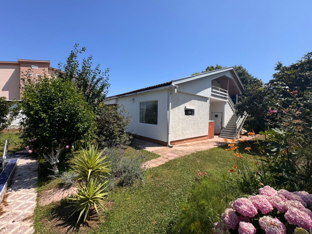Charming single-story white house in Ulcinj, Montenegro with lush garden—prime real estate on montenegro-listings.me by Ekosphere Doo.