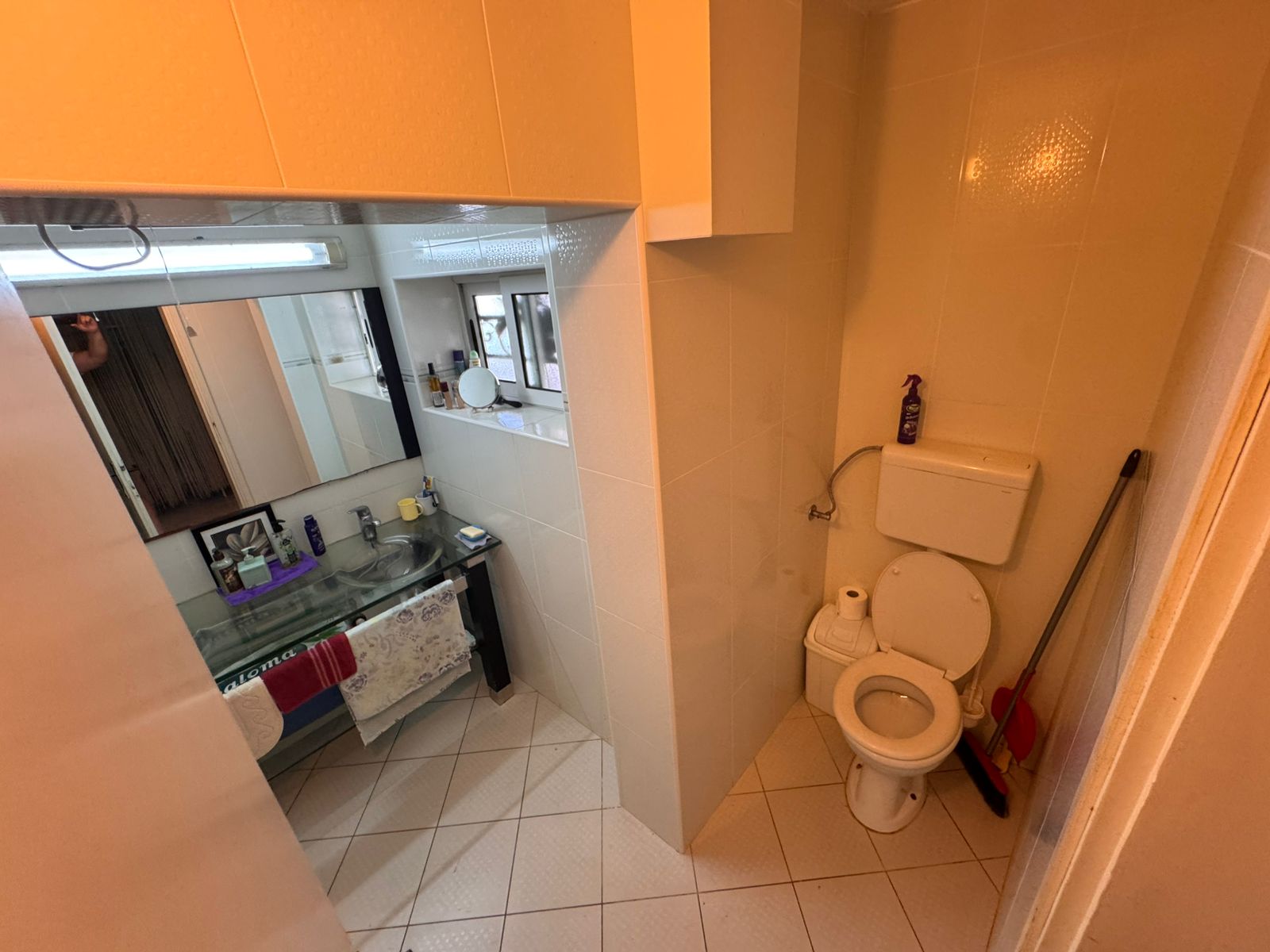 Modern Ulcinj bathroom with beige tiles, glass sink, and large mirror&mdash;prime real estate at montenegro-listings.me by Ekosphere doo.