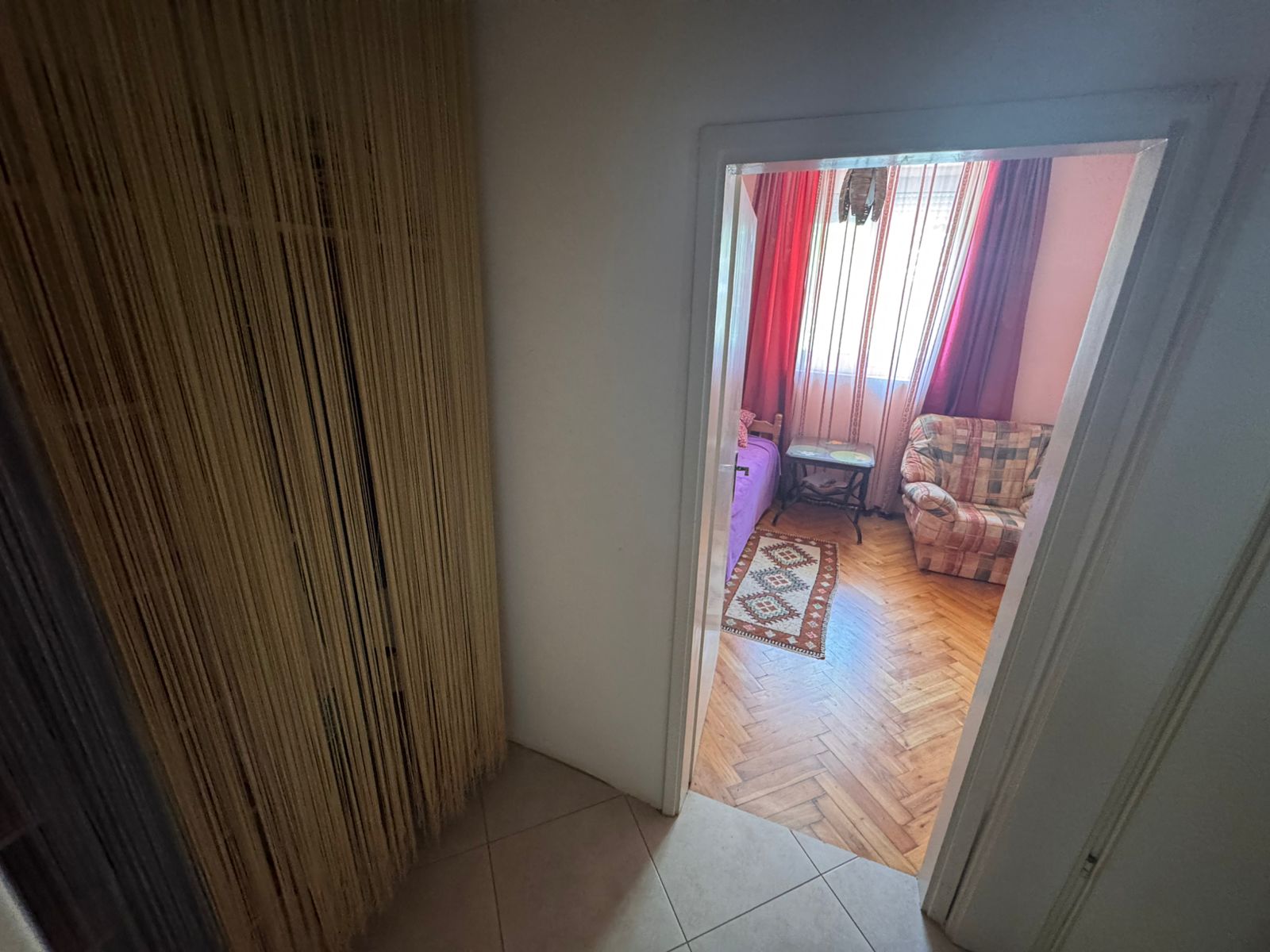 Stylish Ulcinj apartment: tiled hallway, beige string curtain, parquet living room. Prime property by Ekosphere on montenegro-listings.me.