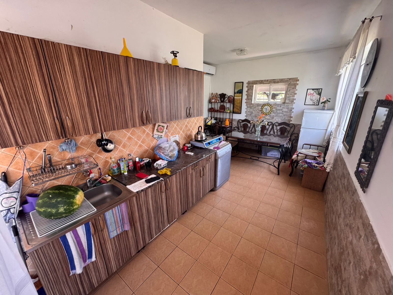 Charming Ulcinj kitchen with wood cabinets, tiled backsplash, and open sitting area&mdash;exclusive at montenegro-listings.me by ekosphere doo.