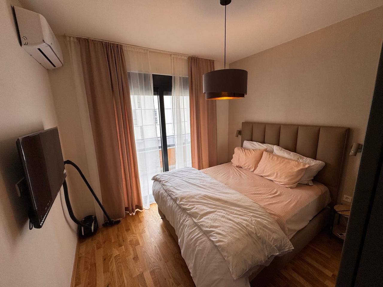 Modern bedroom in Ulcinj with balcony, double bed, and amenities; prime real estate from montenegro-listings.me by ekosphere doo.