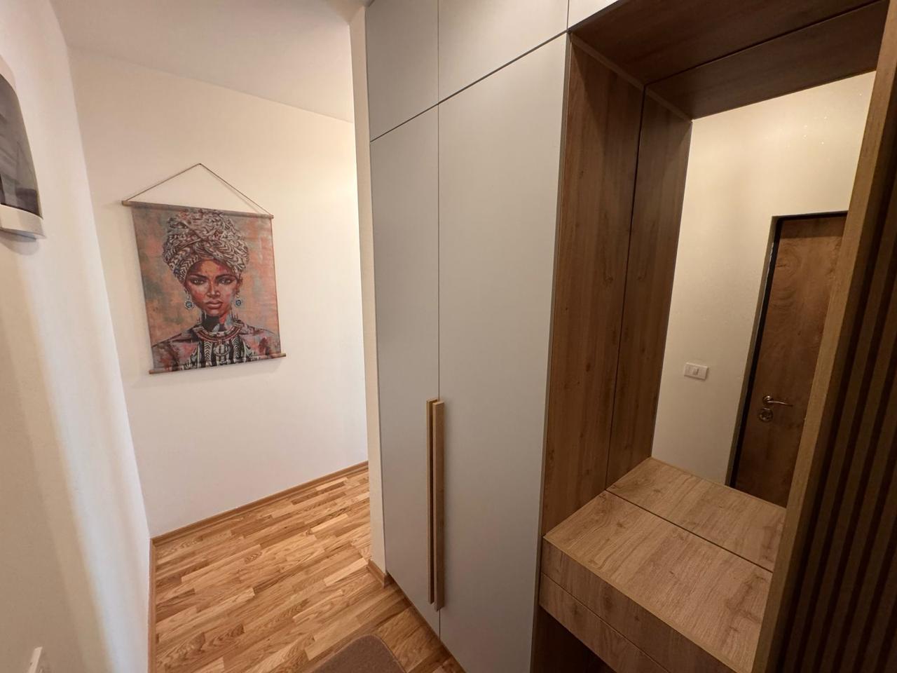 Elegant hallway in Ulcinj property: wooden floors, stylish closet, mirror, art. Invest on montenegro-listings.me by ekosphere doo.