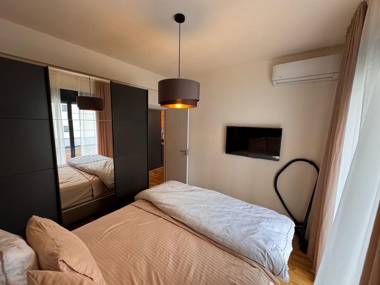 Modern Ulcinj bedroom: beige bedding, black wardrobe, AC, TV. Prime investment via montenegro-listings.me by ekosphere doo.