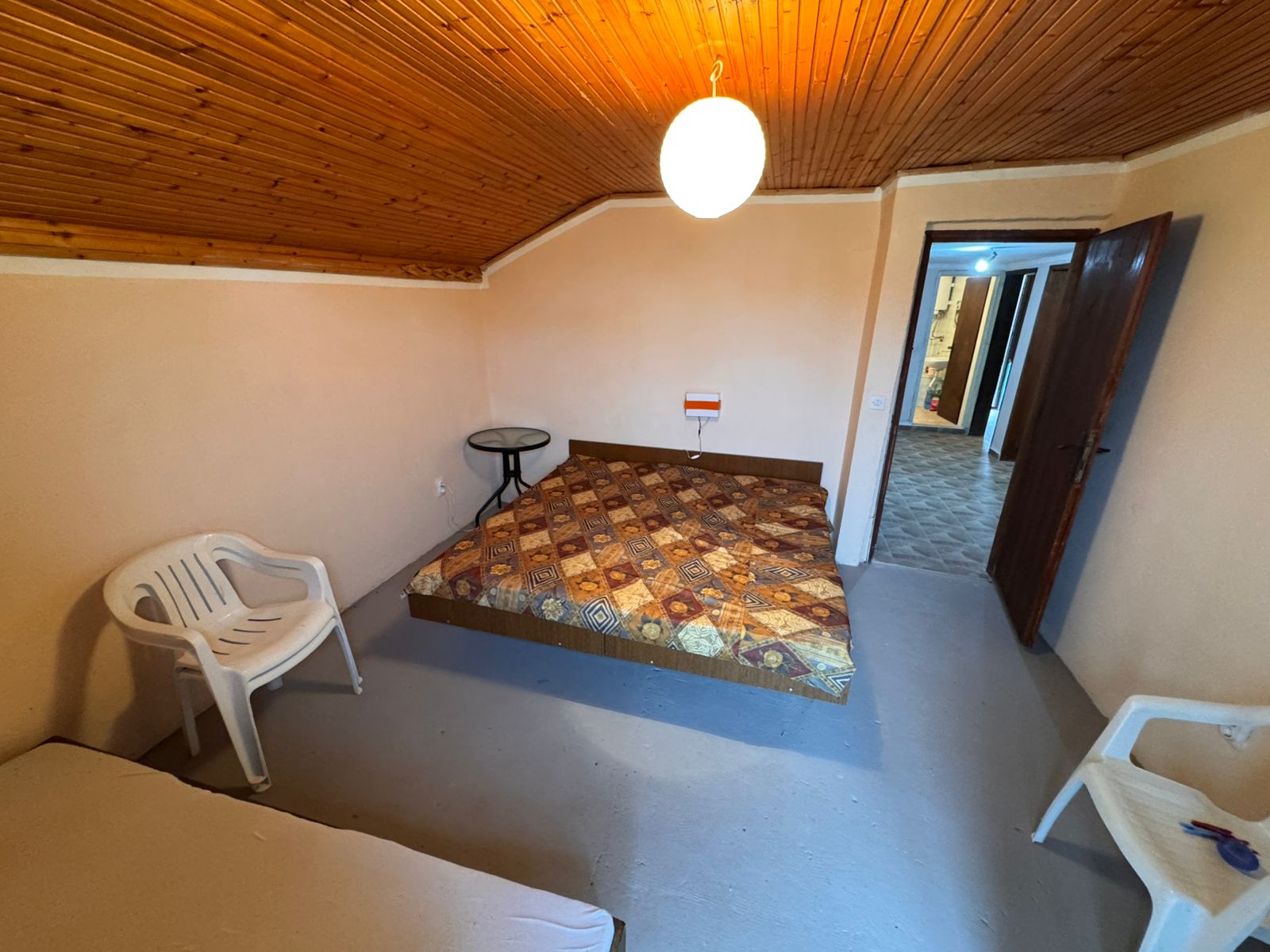 Cozy Ulcinj room with wood paneling, bed, chairs, and table&mdash;investment potential in Montenegro by montenegro-listings.me/Ekosphere doo.