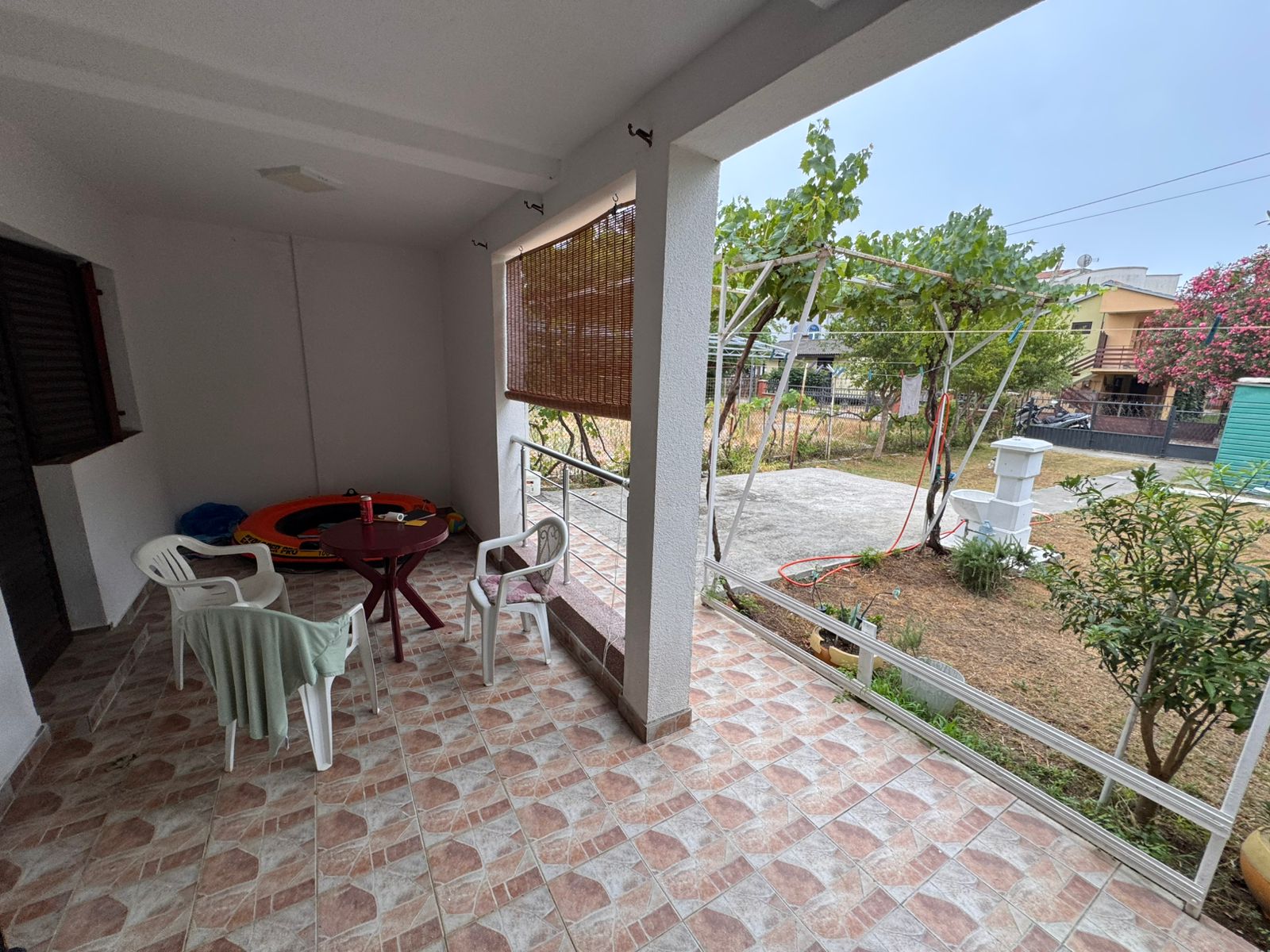 Elegant tiled patio with white columns, ideal for relaxing and entertaining in Ulcinj. Listed by Ekosphere on montenegro-listings.me.