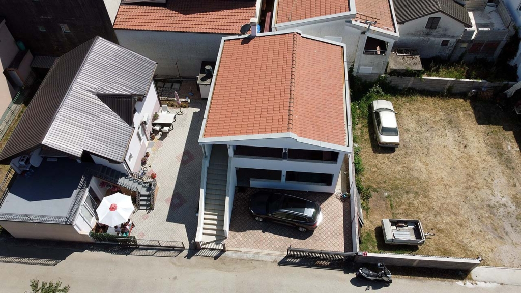 Prime investment opportunity in Ulcinj: two red-roofed homes, outdoor seating, parking, plus large lot—listed on montenegro-listings.me.