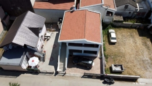 Prime investment opportunity in Ulcinj: two red-roofed homes, outdoor seating, parking, plus large lot—listed on montenegro-listings.me.